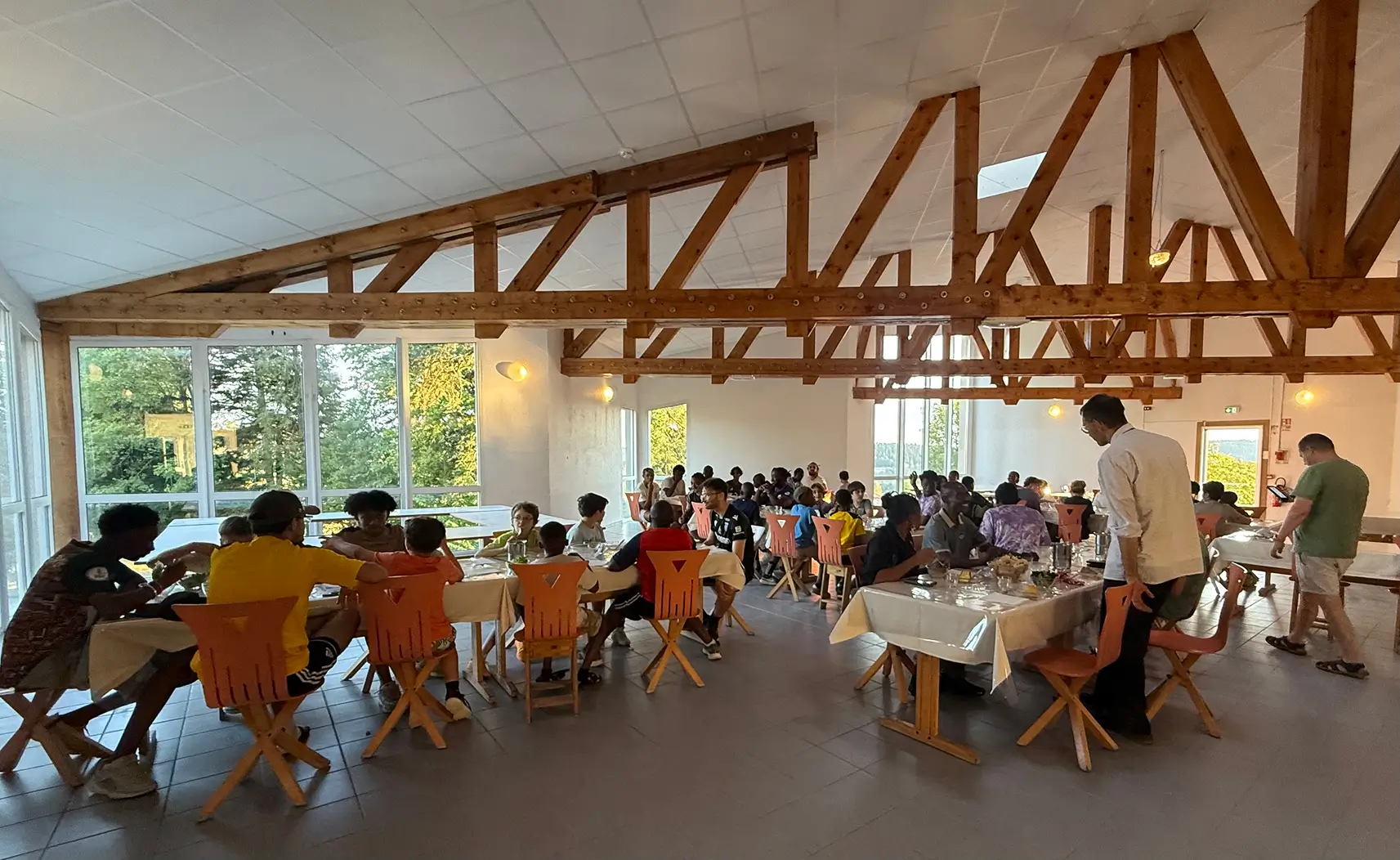 Des dizaines d'enfants mangent dans la salle pour manger